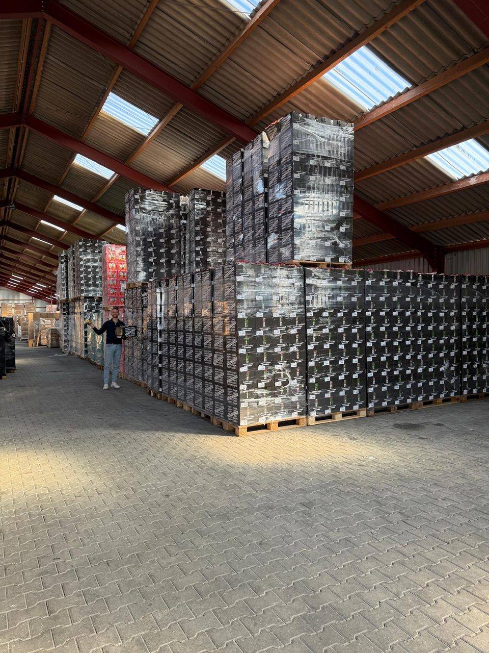 Rows of pallets of crisps in the warehouse, with an employee alongside for scale